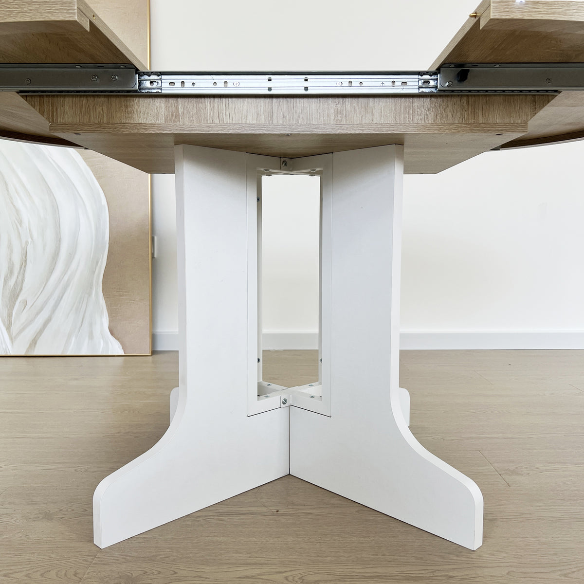 Close-up of the white double-column pedestal base with extension slide rails above