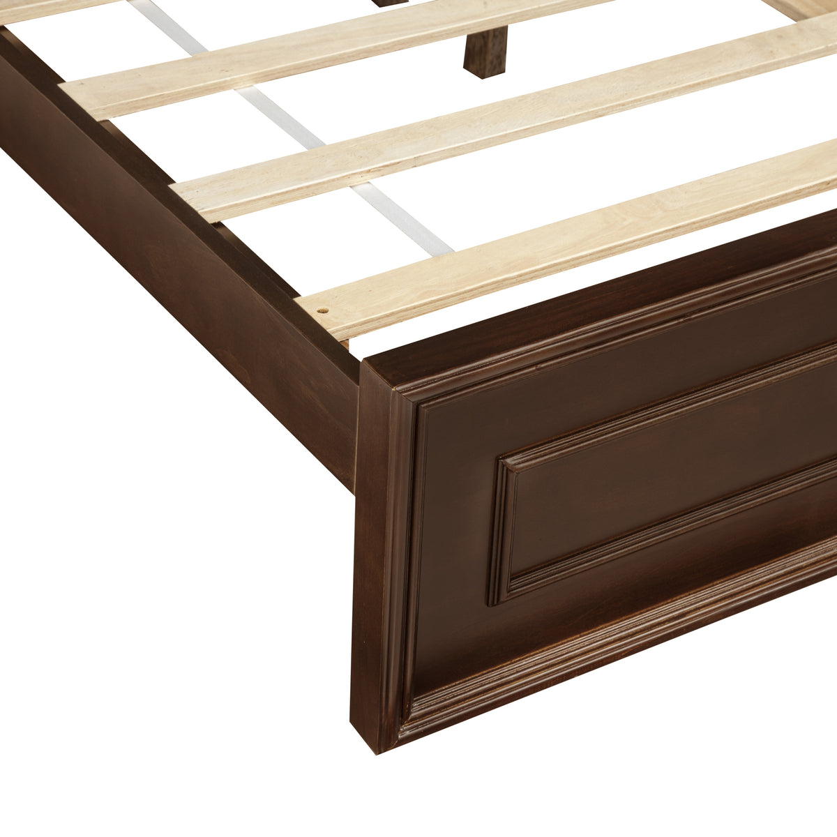 Cropped view of rich brown footboard end with recessed panels and wood slats