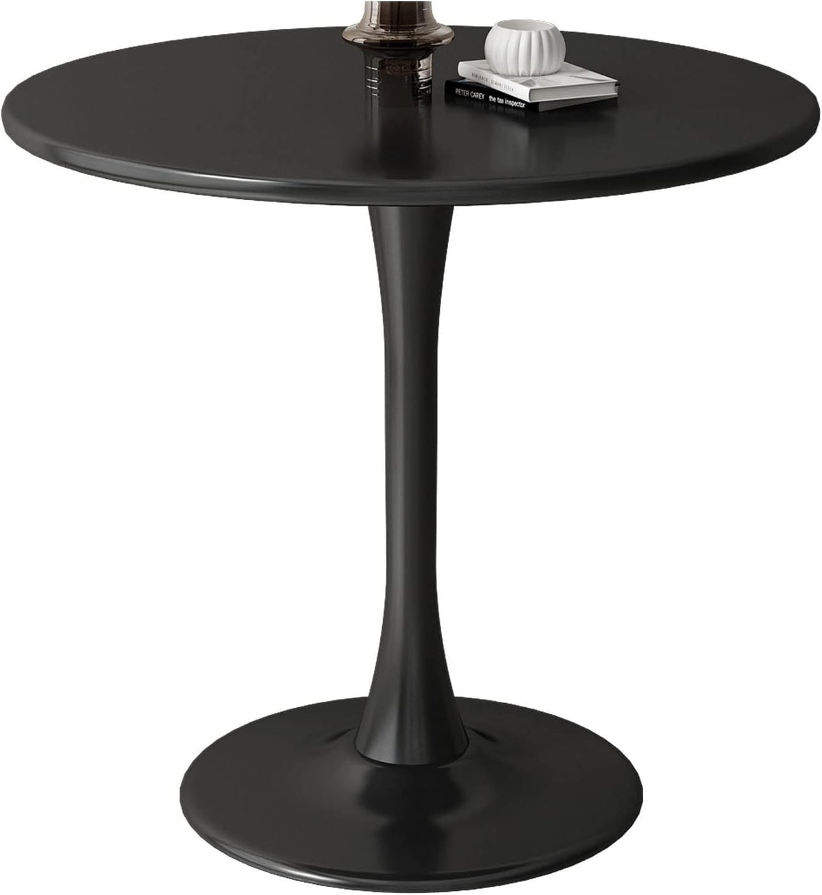 Round black tulip table close view with books, a vase and decor on top