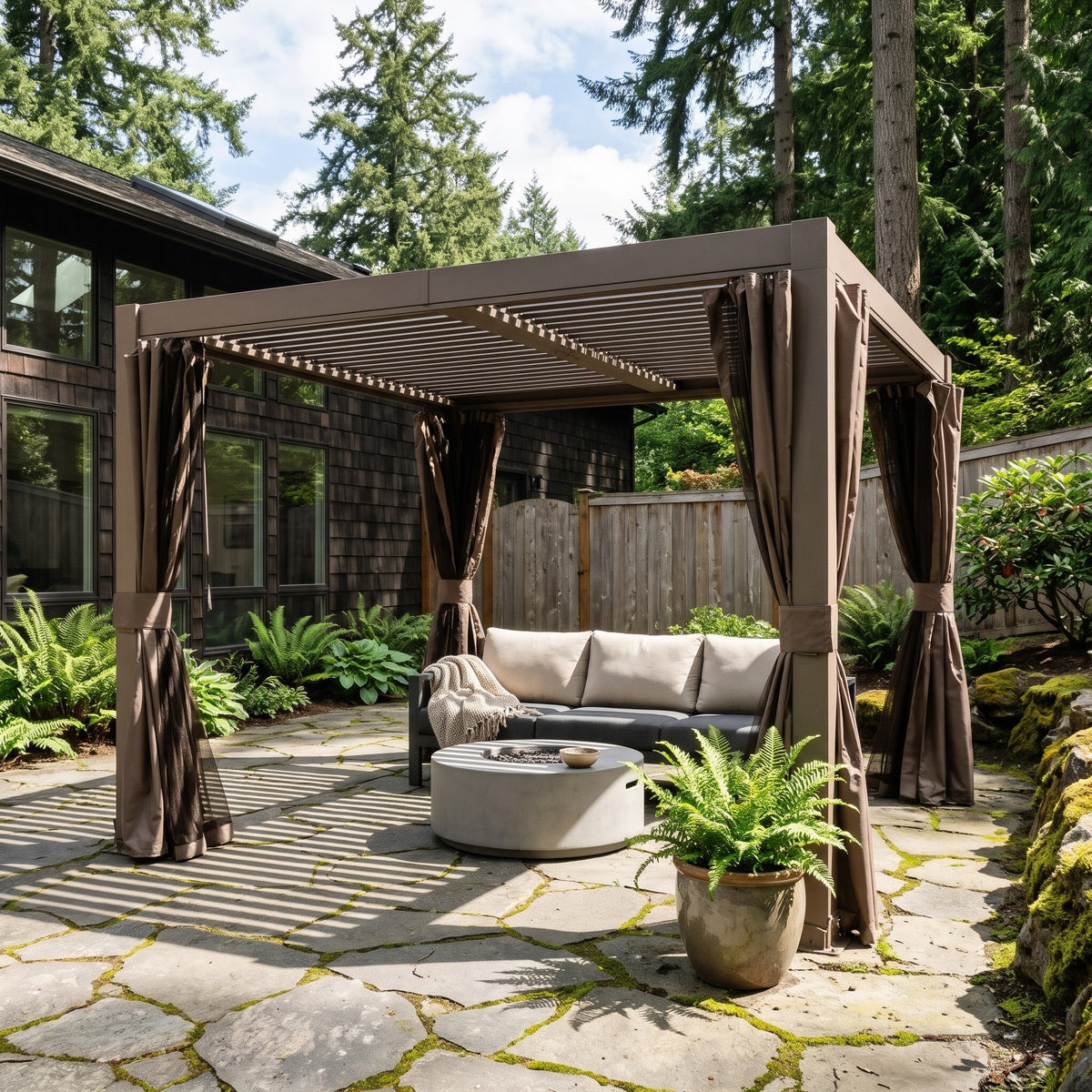 Brown aluminum 10x10 louvered pergola with tied-back curtains over a sofa and fire table on a stone patio