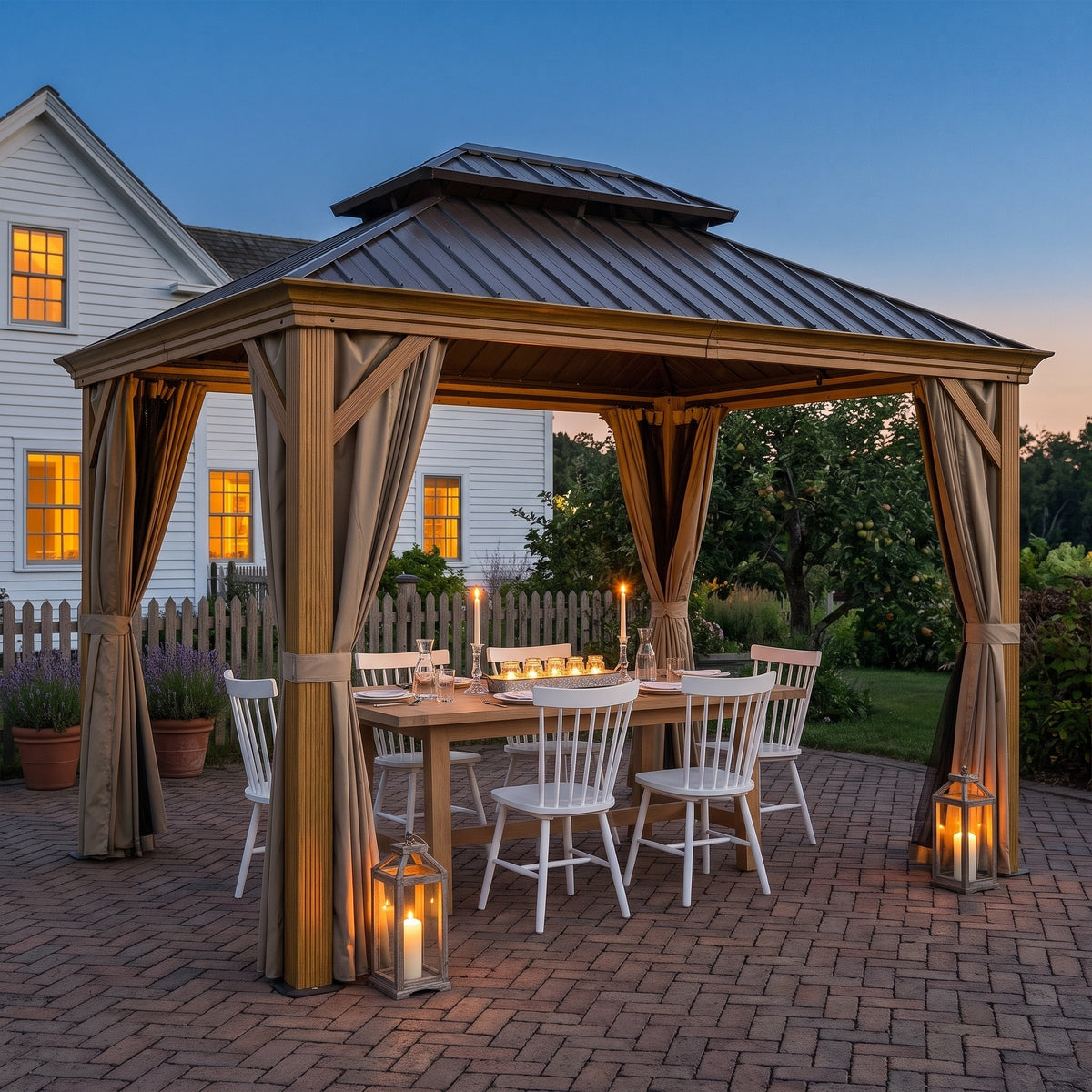 Yellow brown double roof hardtop gazebo with tied back curtains over a candlelit dining table on a brick patio at dusk