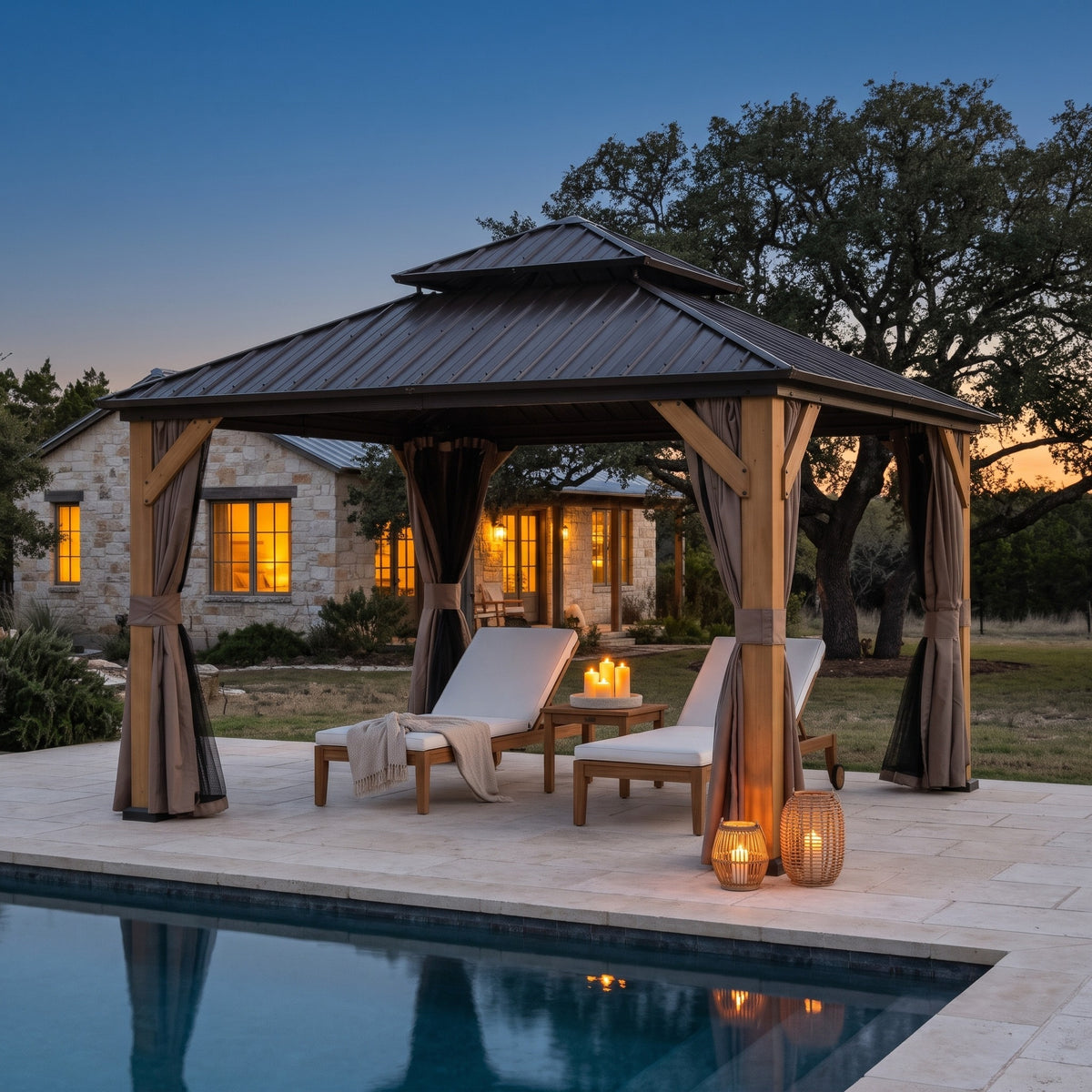Brown wood double roof hardtop gazebo with tied back curtains over two loungers by a pool at dusk