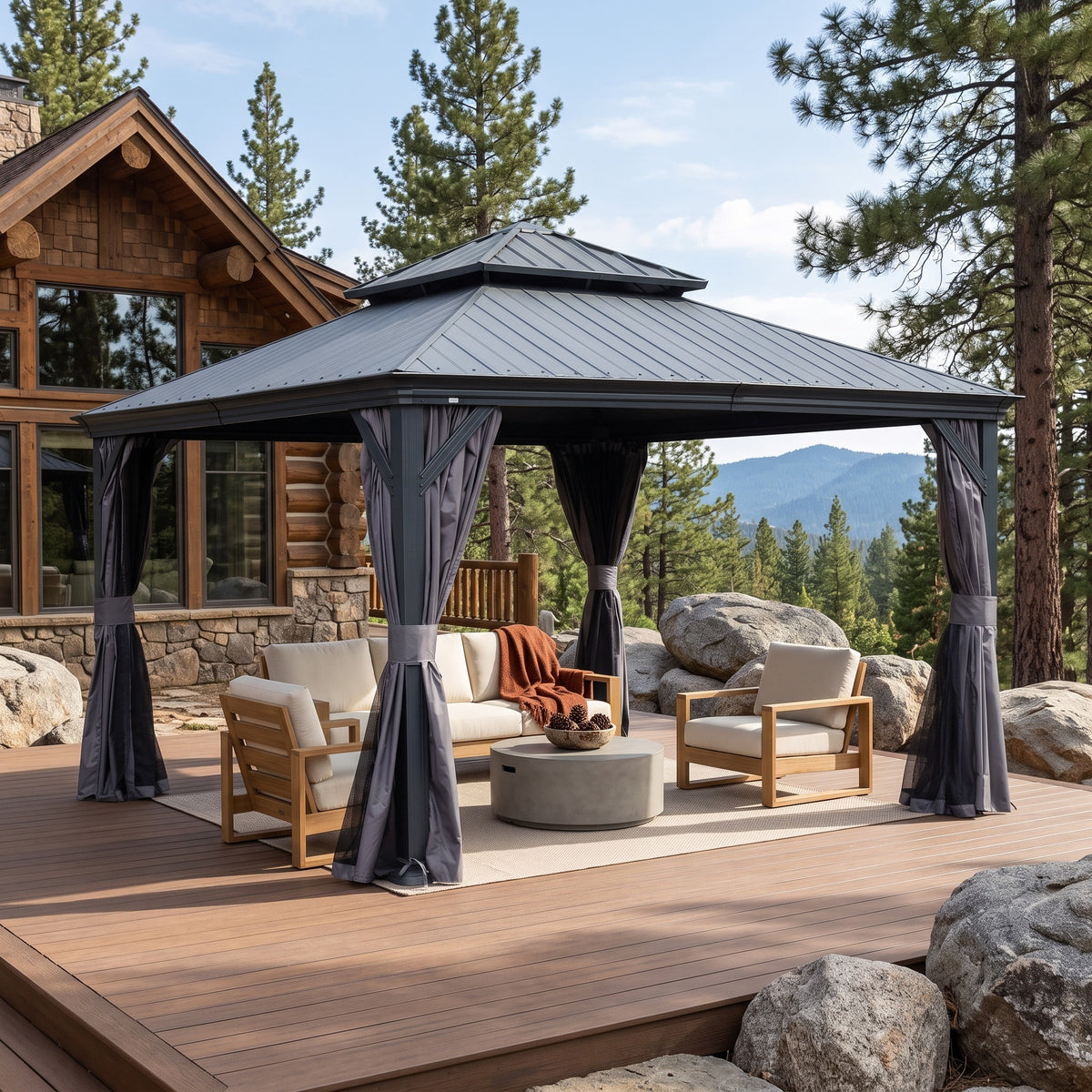 Dark gray 12x12 hardtop gazebo with gray curtains over a sofa and lounge chairs on a wood deck by pine trees