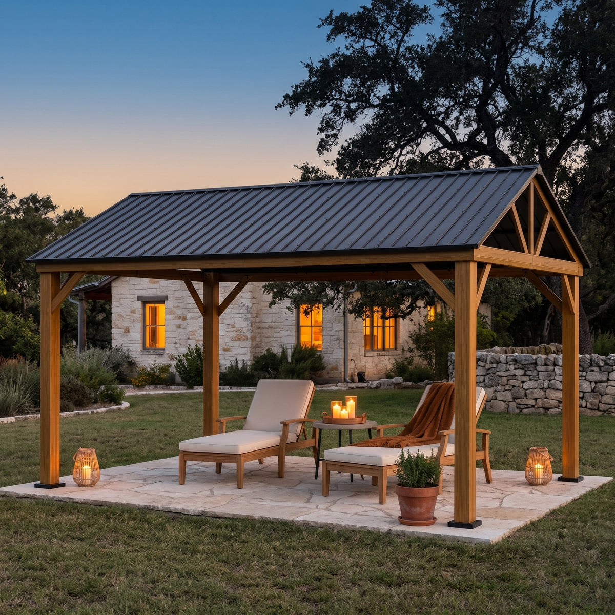 Yellow brown aluminum 12x14 hardtop gazebo with gray steel gable roof over two lounge chairs on a stone patio at dusk