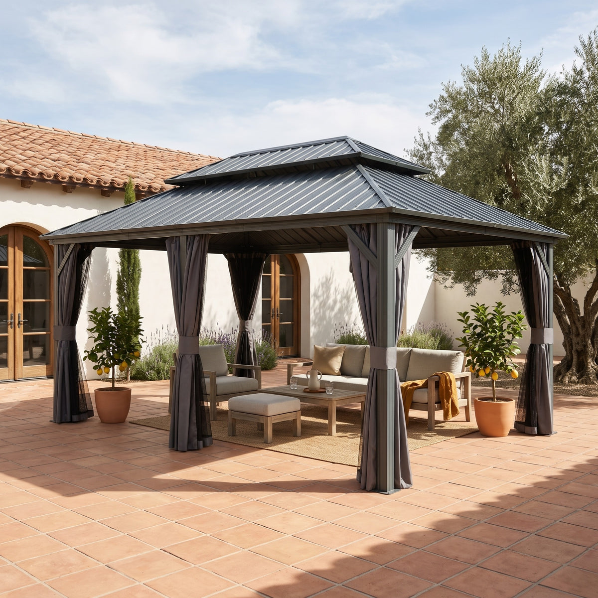 Gray aluminum 12x18 double roof hardtop gazebo with tied back curtains over a lounge set on a terracotta patio
