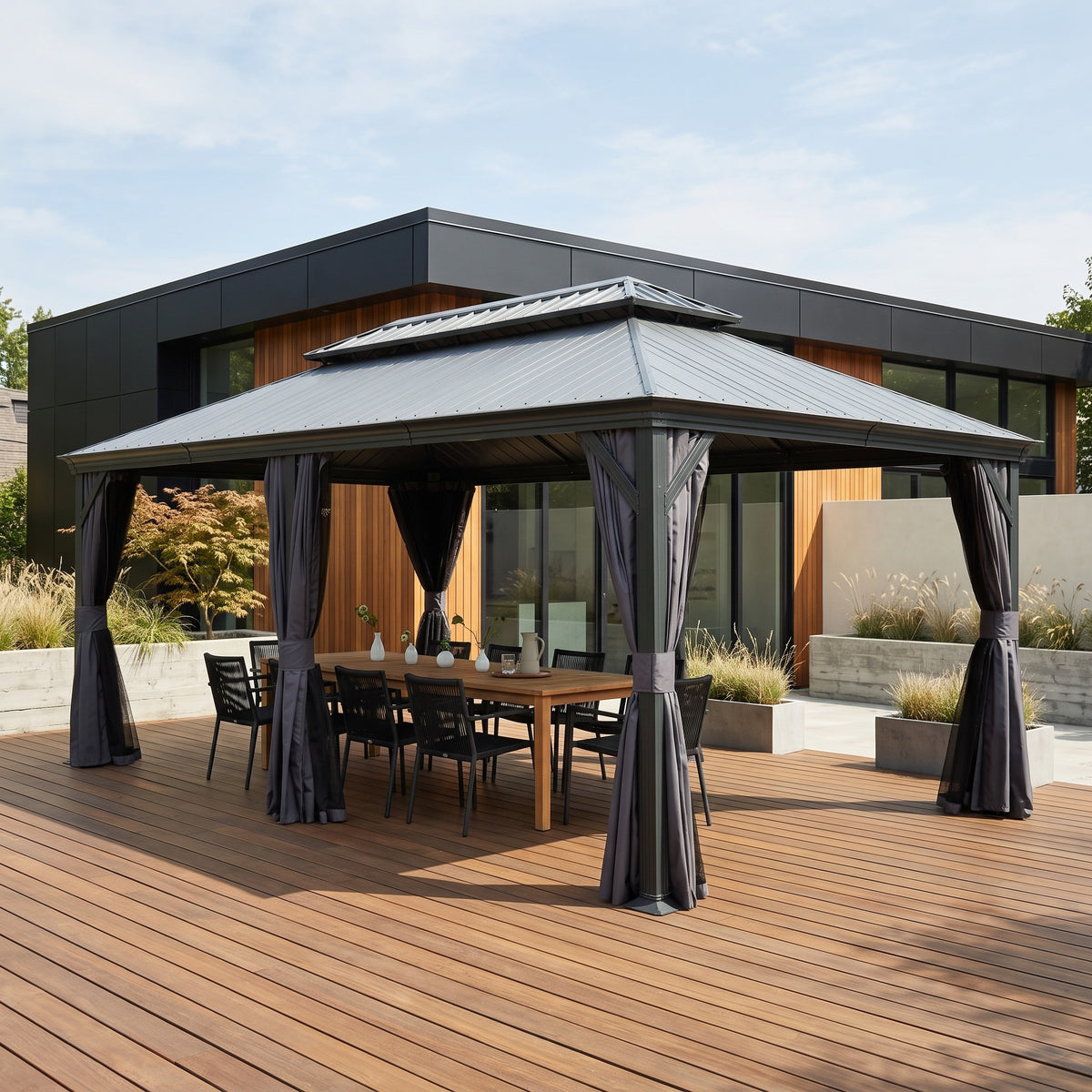 Dark gray 12x20 hardtop gazebo with tied-back curtains over a teak dining table on a wood deck