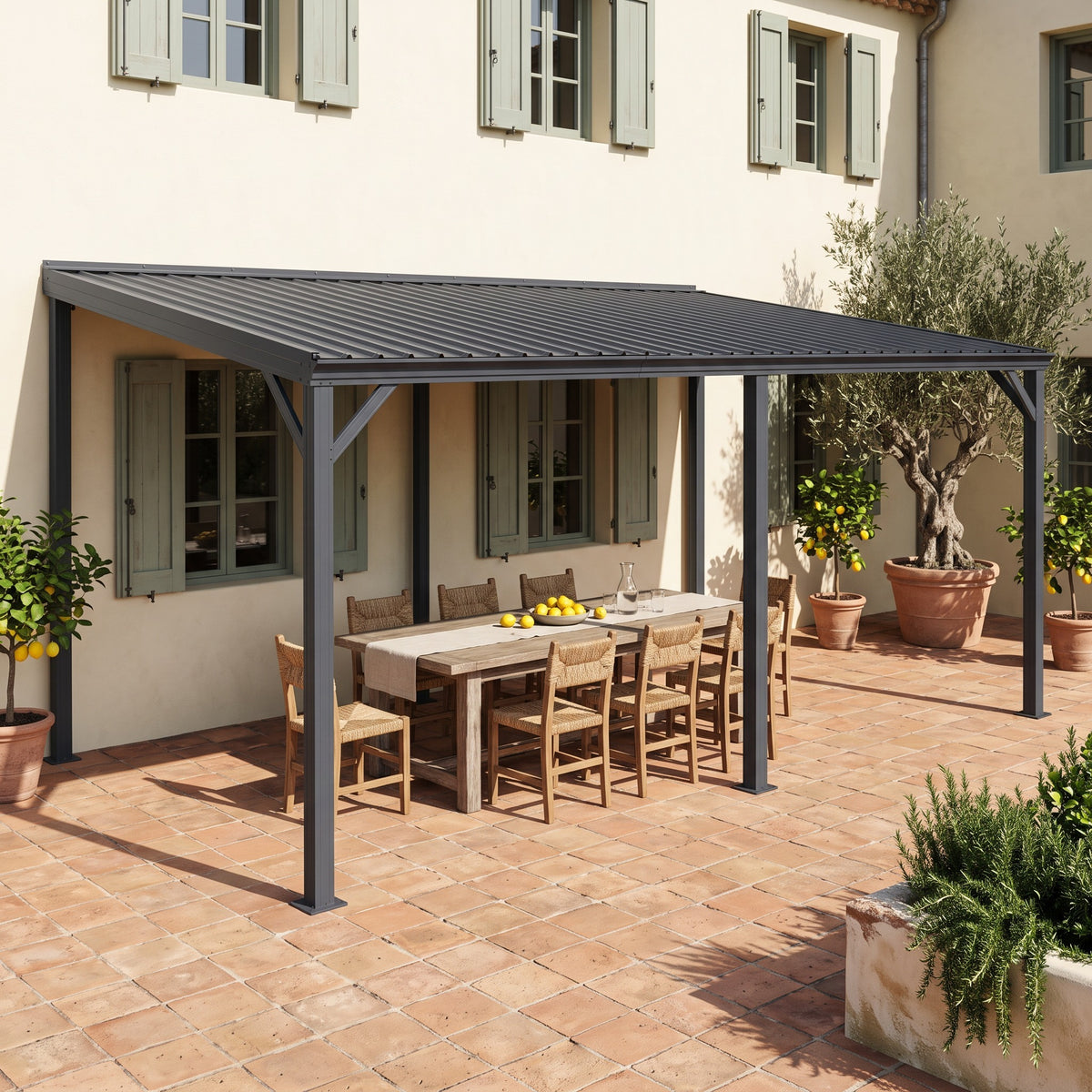 Gray metal 12x20 lean-to hardtop gazebo on a cream house wall over a wood dining table on a terracotta patio