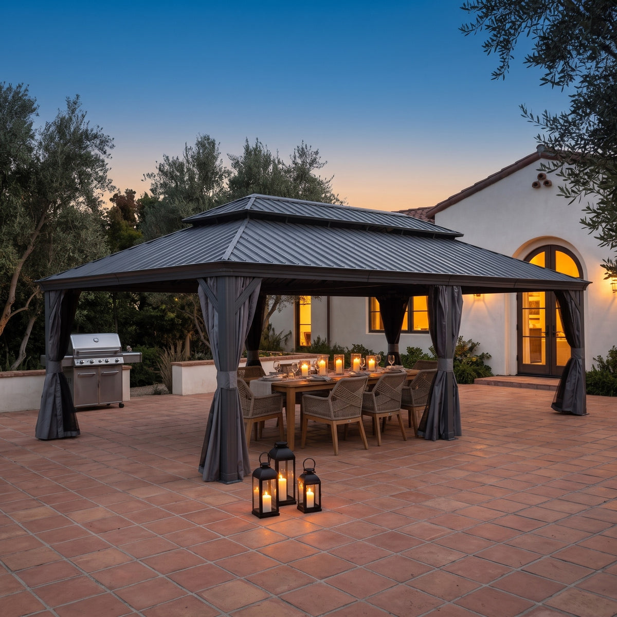 Gray aluminum 14x24 double roof hardtop gazebo with tied curtains over a candlelit dining table on a tile patio at dusk