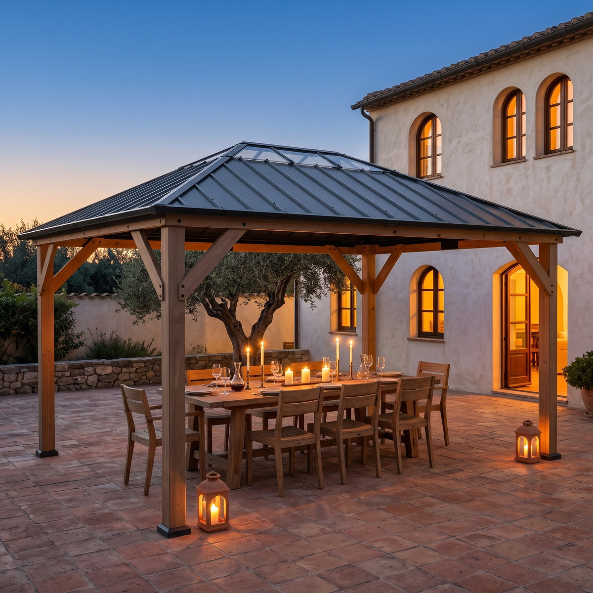 Gray steel roof hardtop gazebo with wood posts over a candlelit dining table on a terracotta patio at dusk