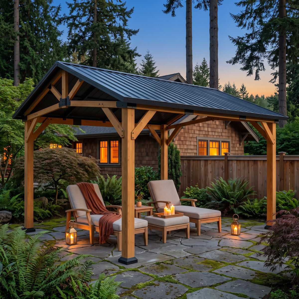 Fir wood gazebo with black gable metal roof over two loungers on a flagstone patio at dusk, lit by lanterns