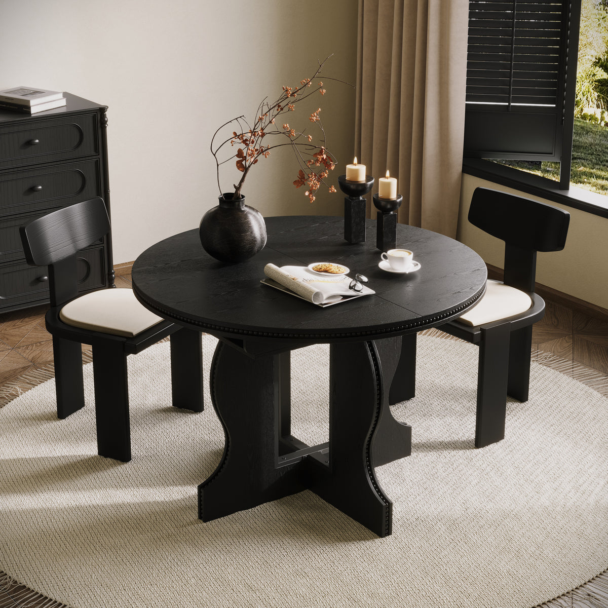 Black round pedestal dining table in its round form, overhead angle in a styled dining room with two black chairs