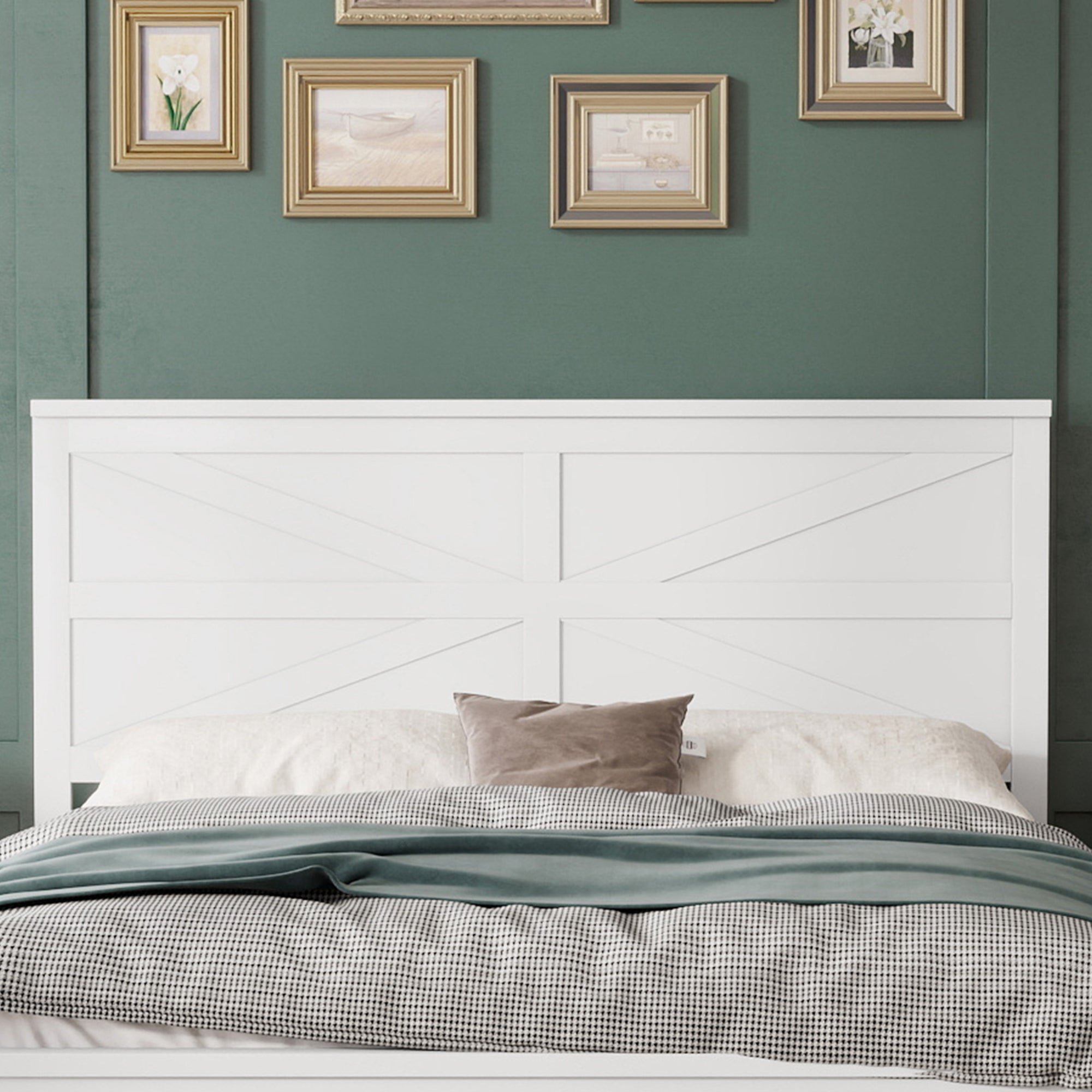 Close front view of the white barn door headboard with crossed board bracing against a green wall with framed art