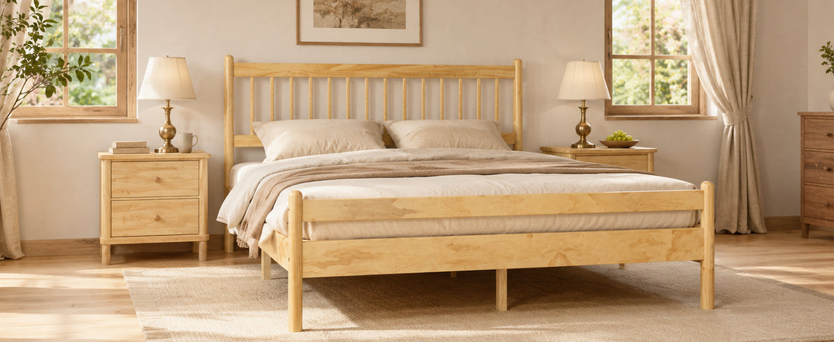 Angled sunlit bedroom view of the natural pine bed with cream bedding and pine nightstands