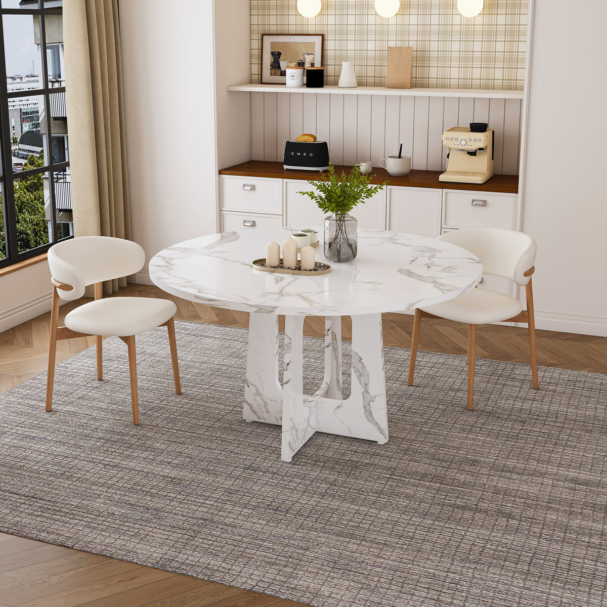 White faux marble round dining table with two cream chairs in a styled dining room, front view