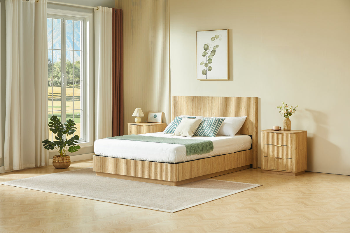 Front view of light oak fluted queen bed centered in a bright bedroom between two nightstands