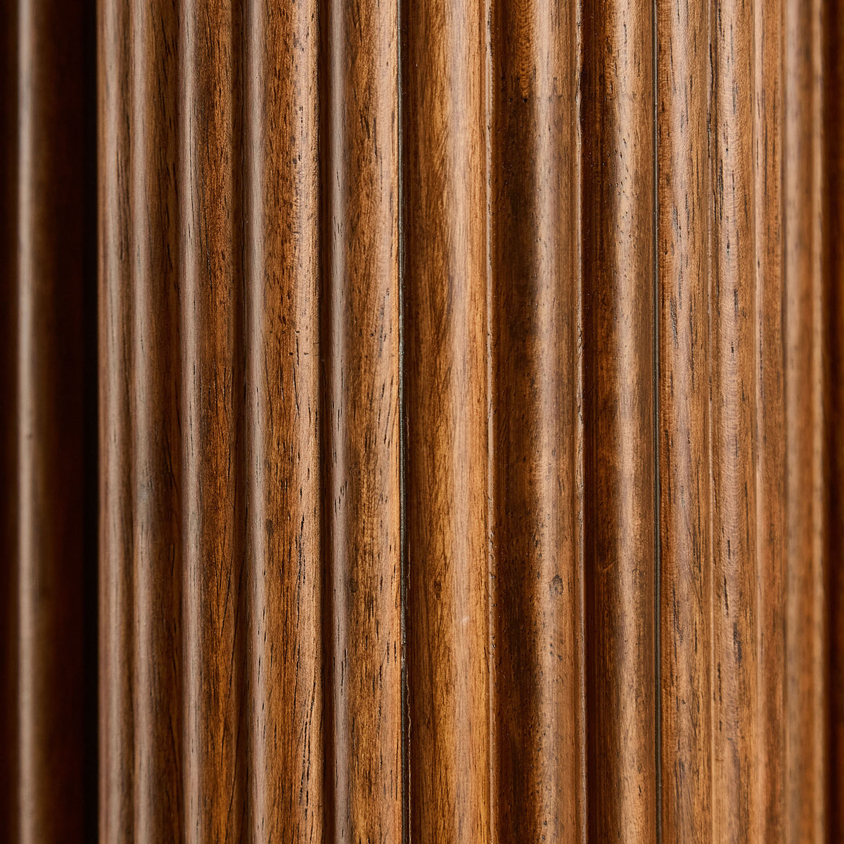 Extreme close-up of the vertical fluted grooves on the walnut column