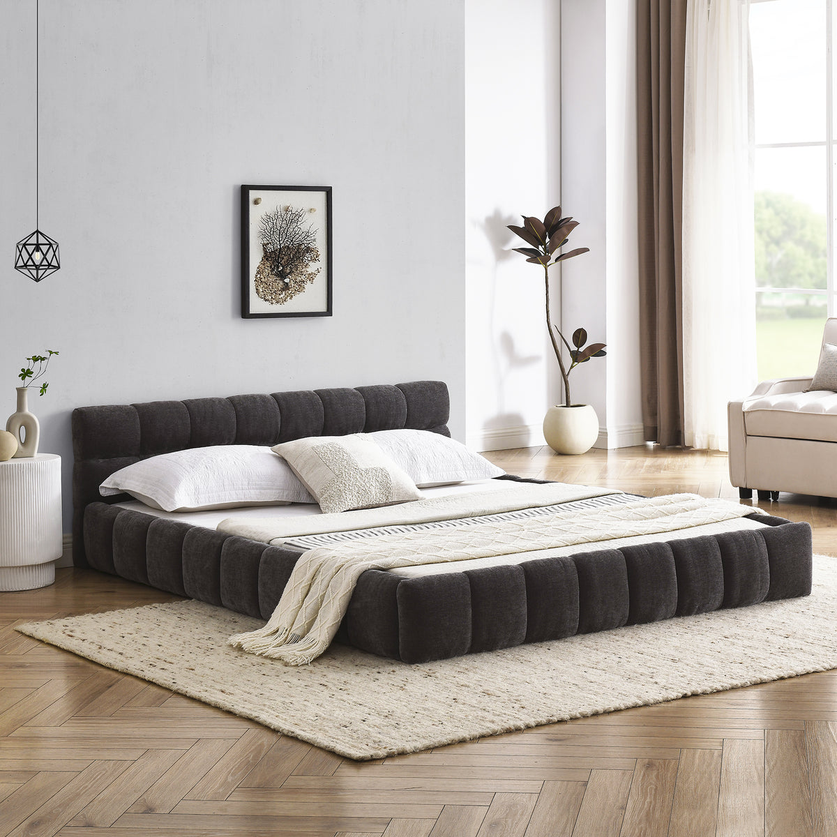 Dark grey chenille platform bed viewed head-on from the foot in a styled bedroom