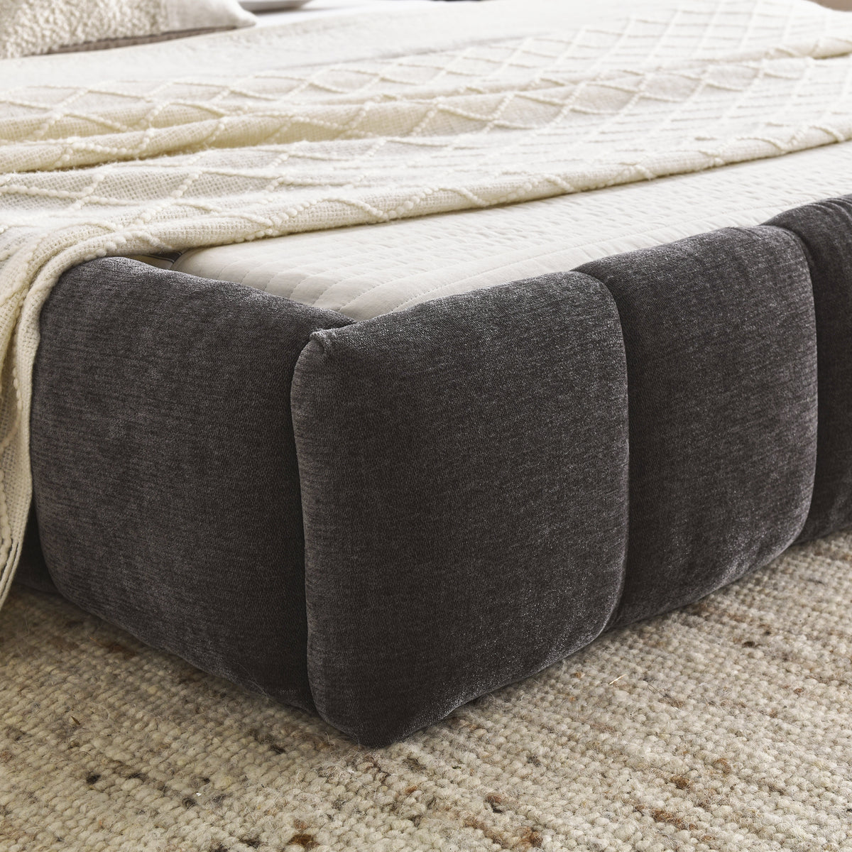 Close-up of the dark grey chenille bubble-tufted foot rail corner with white bedding