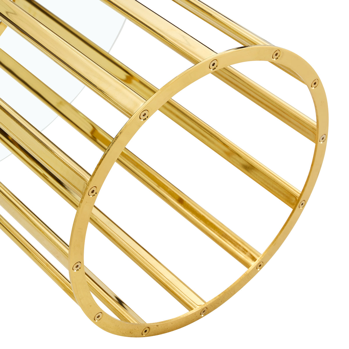 Angled close-up of a gold column base and the glass edge of the dining table on white