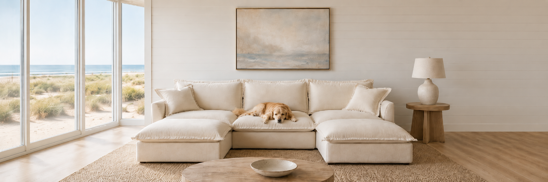 Cream modular sectional with a golden retriever resting on it in a bright beachfront living room