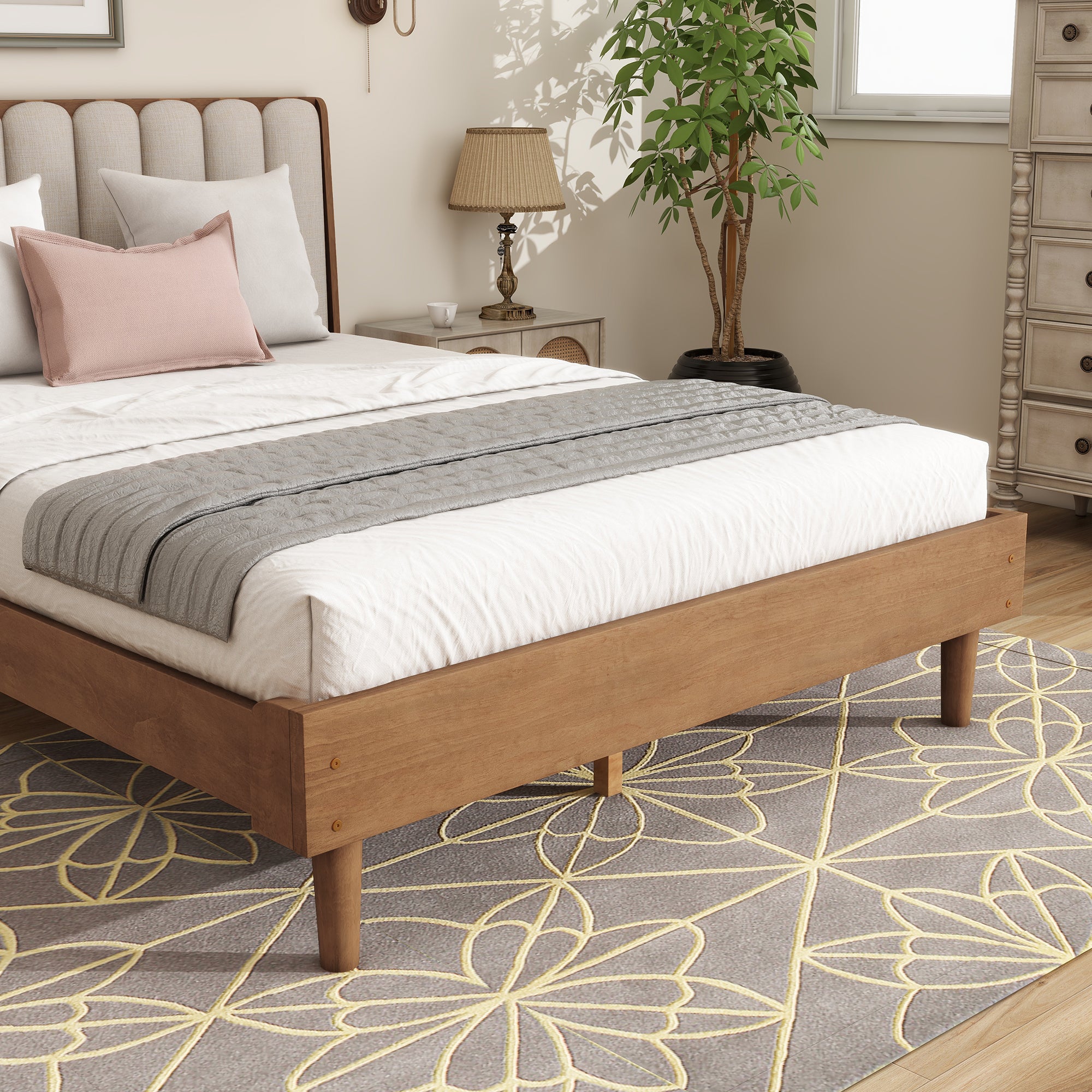 Foot-end detail of the wood platform bed showing the warm-toned rail with dowel joints and tapered wood legs