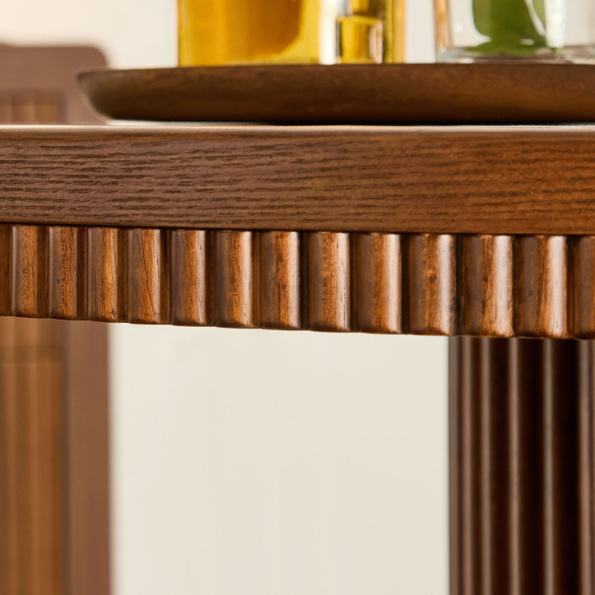 Close-up of the fluted wood apron beneath the round table's stone top