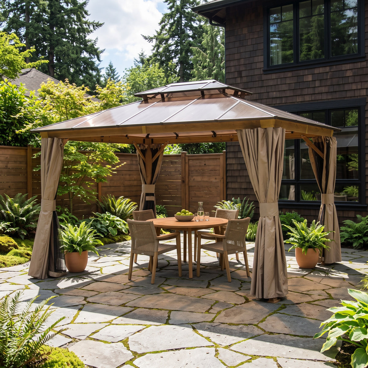 Brown 10x12 double roof hardtop gazebo with tan curtains over a round teak dining set on a flagstone patio
