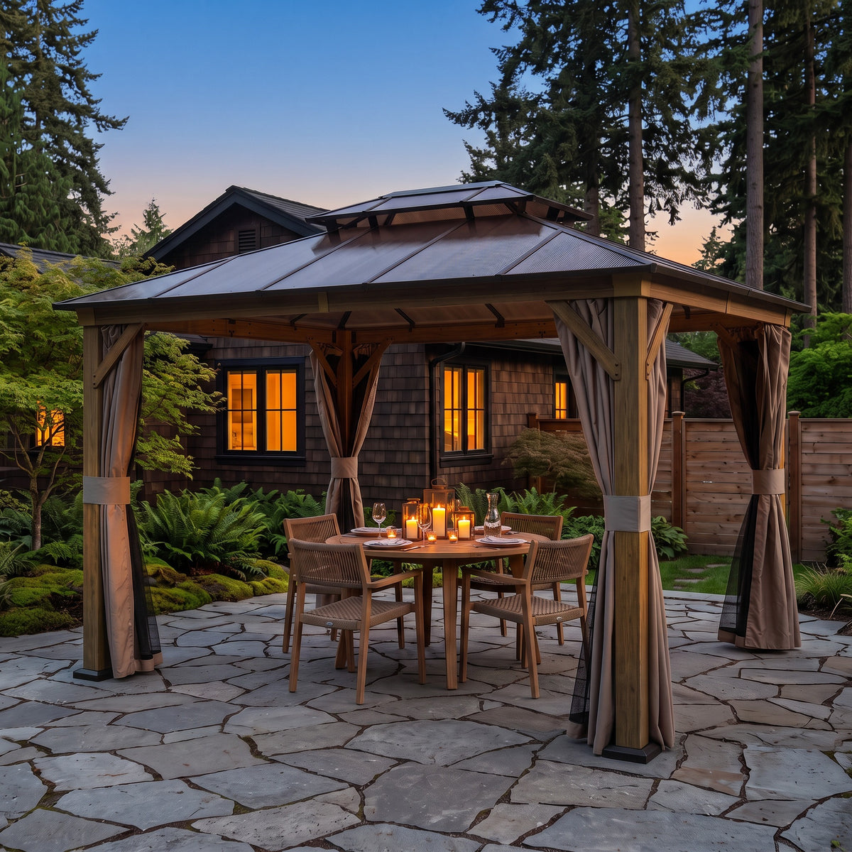 Wood-grain aluminum 10x12 double roof gazebo with tan curtains over a candlelit dining table on a flagstone patio at dusk