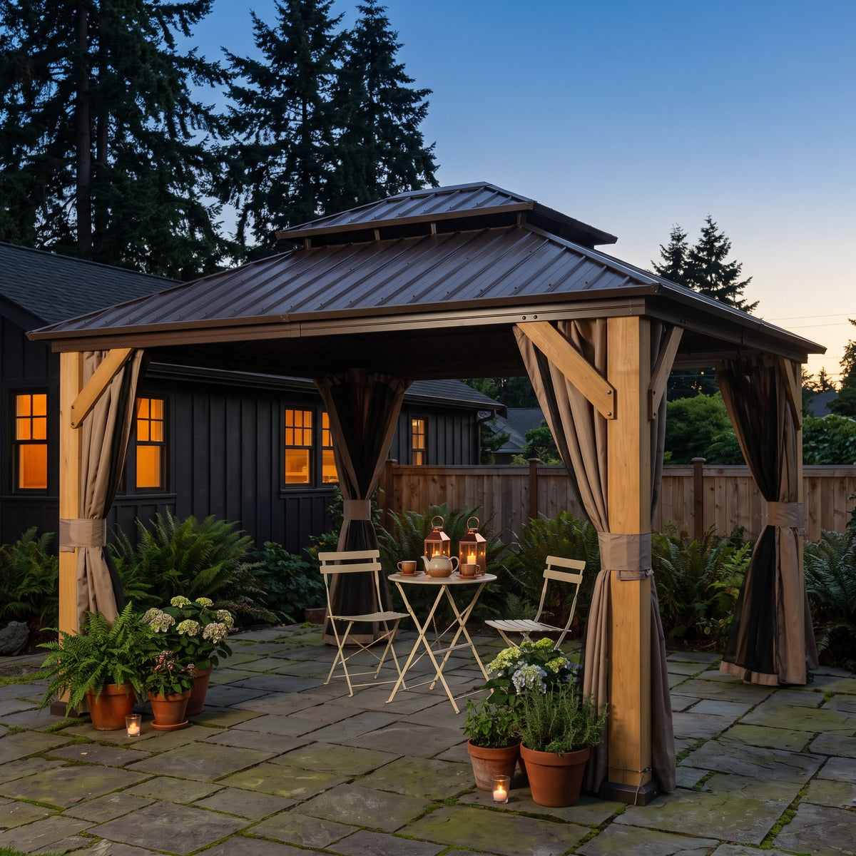 Brown cedar double roof hardtop gazebo with tied back curtains over a bistro set on a stone patio at dusk