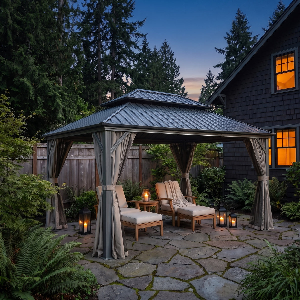 Gray aluminum 10x14 double roof hardtop gazebo with tied back curtains over lounge chairs on a flagstone patio at dusk