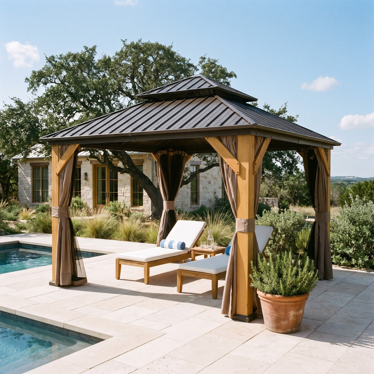 Brown wood double roof hardtop gazebo with tied back curtains over two loungers beside a pool on a stone patio