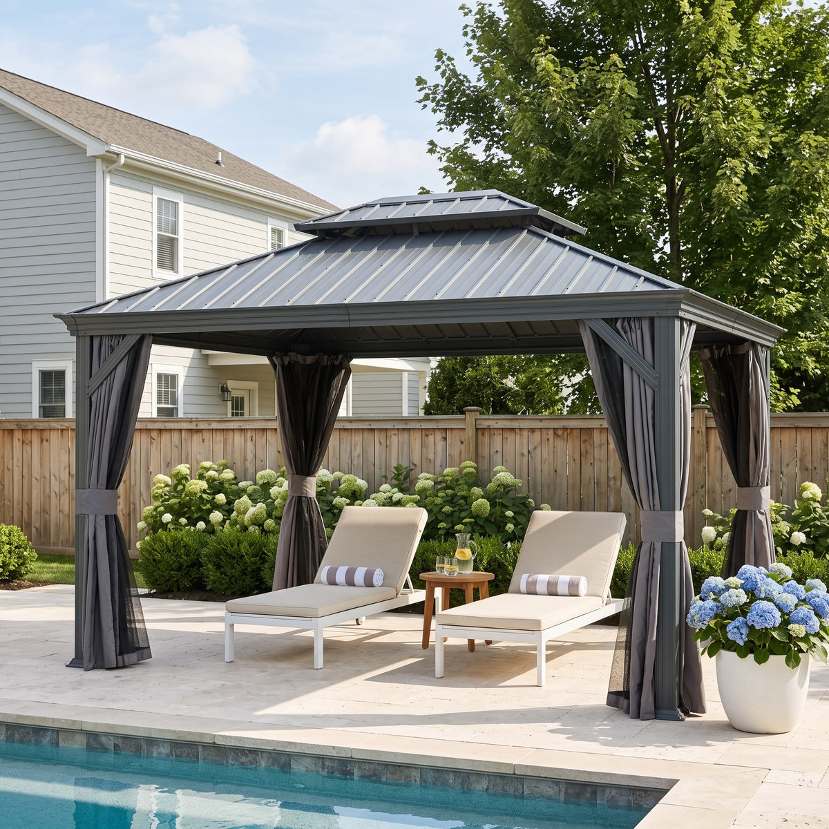 Gray 12x14 hardtop gazebo with tied back curtains over two loungers beside a pool on a stone patio