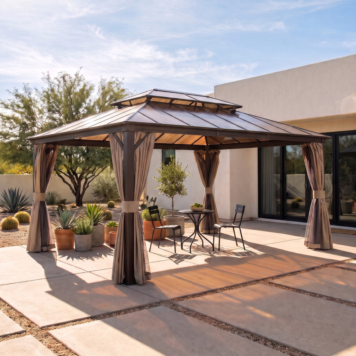 Brown aluminum 12x16 double roof hardtop gazebo with tied back curtains over a bistro set on a desert patio