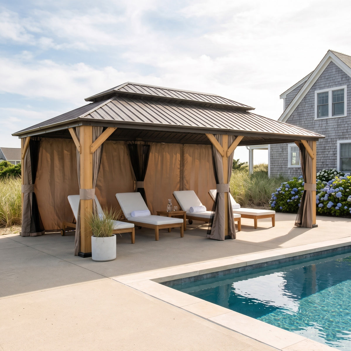 Brown cedar 12x20 hardtop gazebo with double roof and tan curtains shading loungers beside a pool on a sunny day