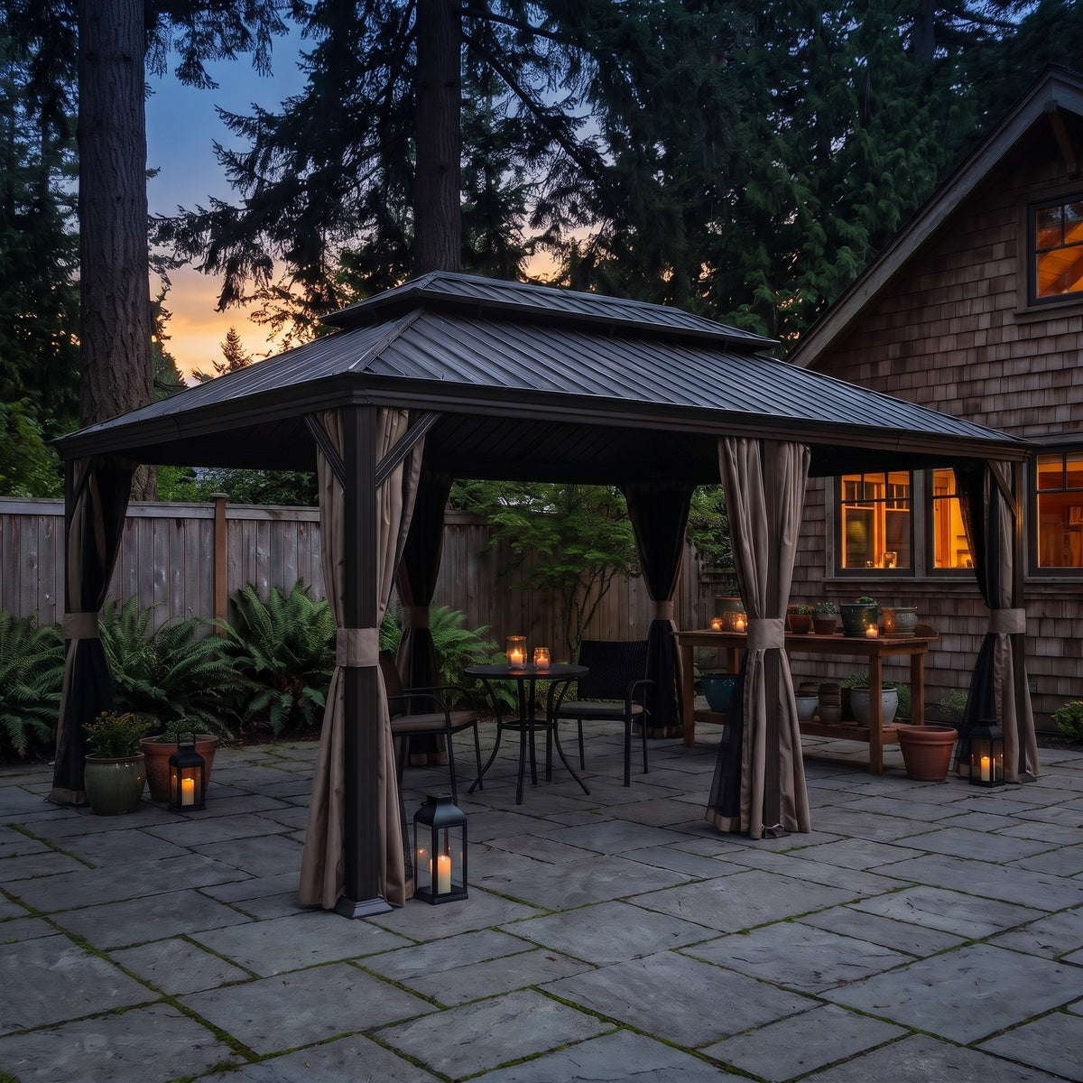 Brown 12x20 hardtop gazebo with tan curtains and netting over a bistro set on a stone patio at dusk