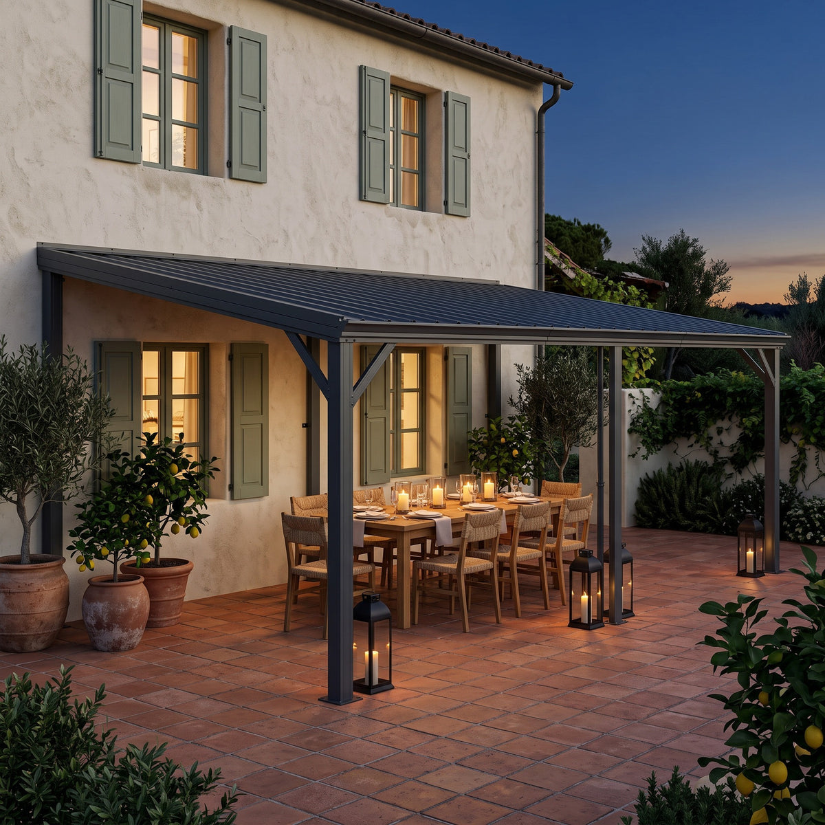 Gray metal lean-to hardtop gazebo on a house wall over a candlelit dining table on a tile patio at dusk