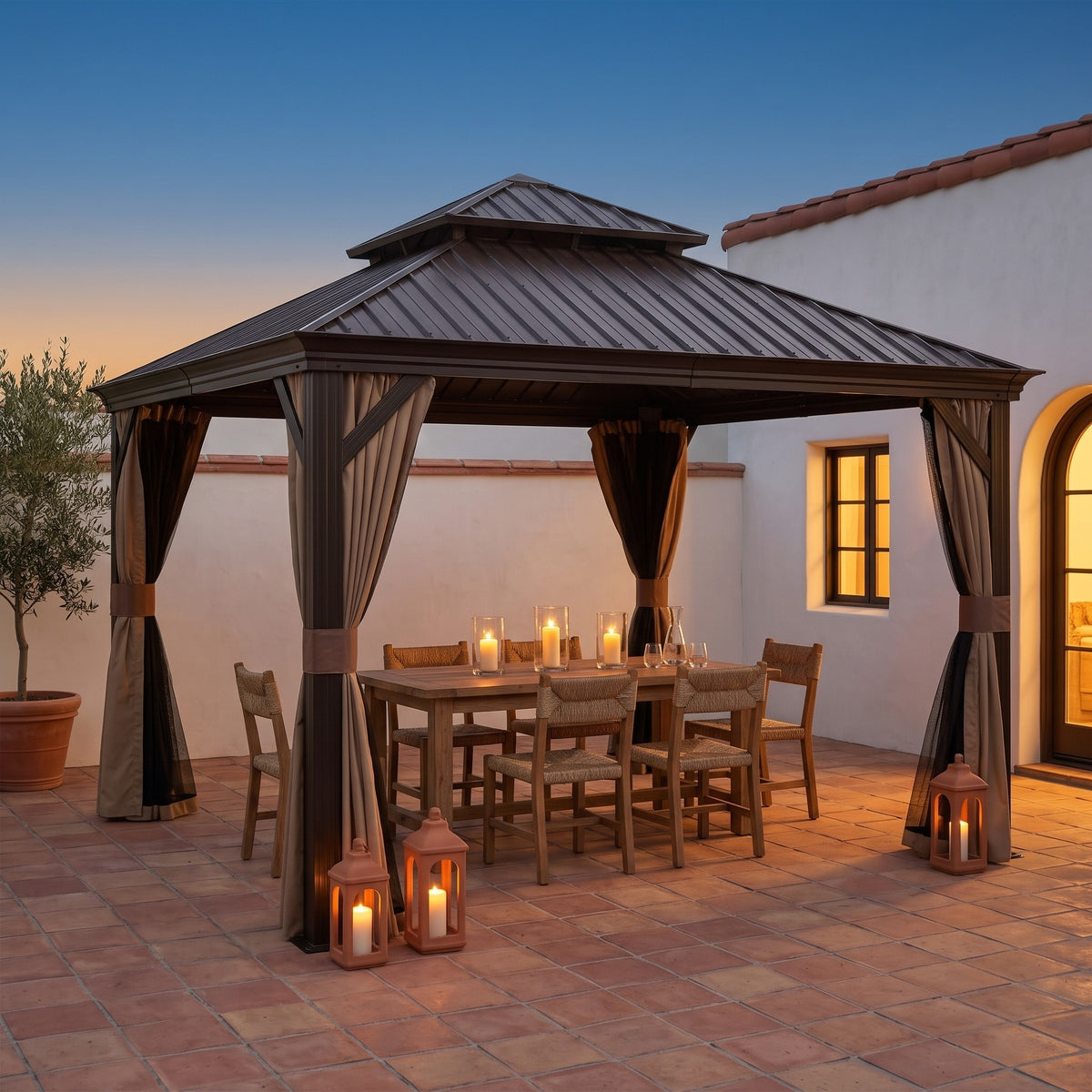 Brown steel 13x13 double roof gazebo with tan curtains over a candlelit dining table on a terracotta patio at dusk