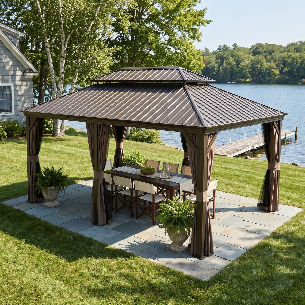 Brown aluminum 14x20 double roof hardtop gazebo with tied curtains over a dining table on a lakeside stone patio
