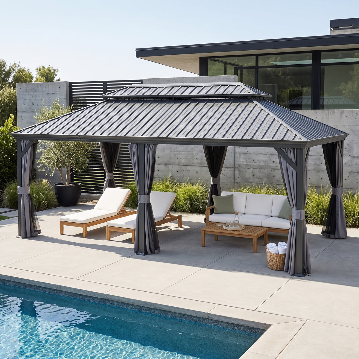 Gray 14x24 hardtop gazebo with curtains tied back over loungers and a sofa beside a pool on a concrete patio