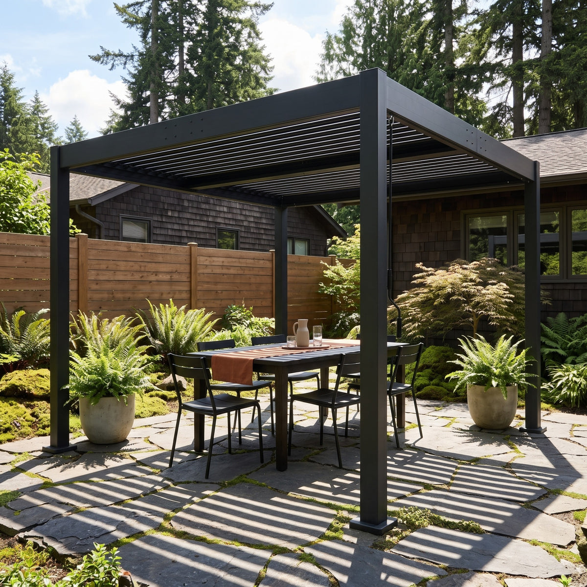 Black louvered aluminum pergola over a dining table on a flagstone patio with ferns in afternoon sun