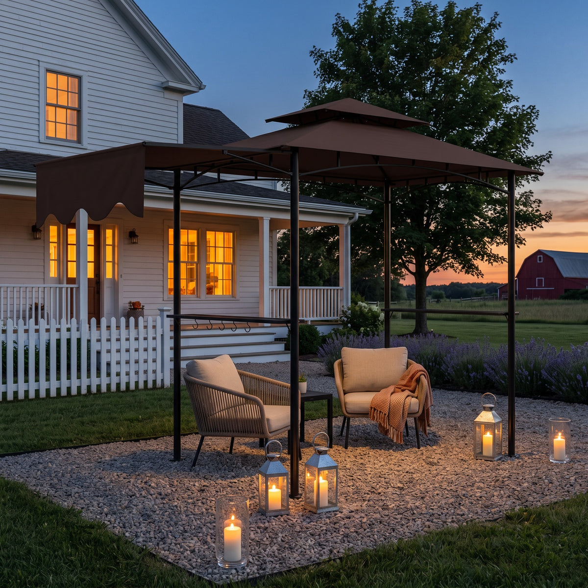 Brown metal patio gazebo with double tier canopy over lounge chairs on gravel at dusk, lit by lanterns