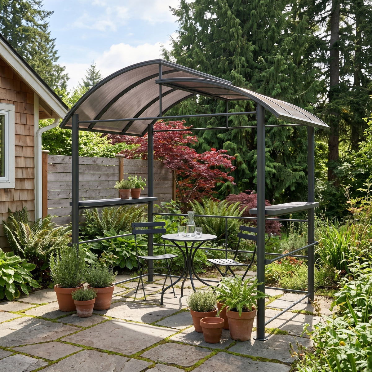 Dark gray metal grill gazebo with brown polycarbonate roof and side shelves over a bistro set on a stone garden patio