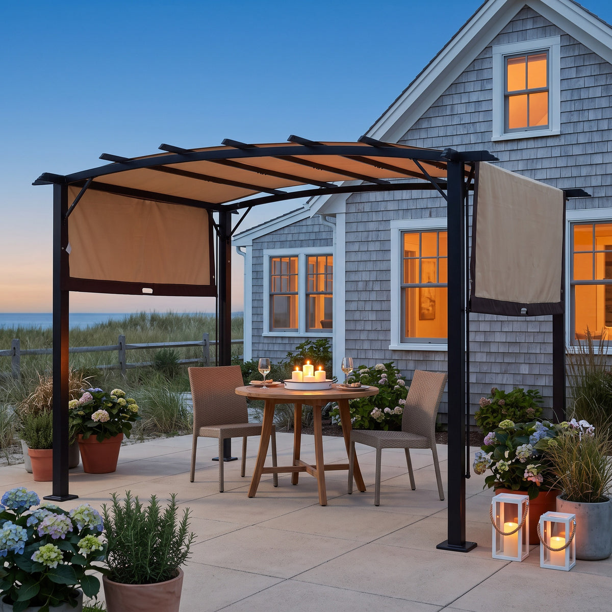 Black steel pergola with beige retractable canopy over a bistro table for two on a coastal patio at dusk