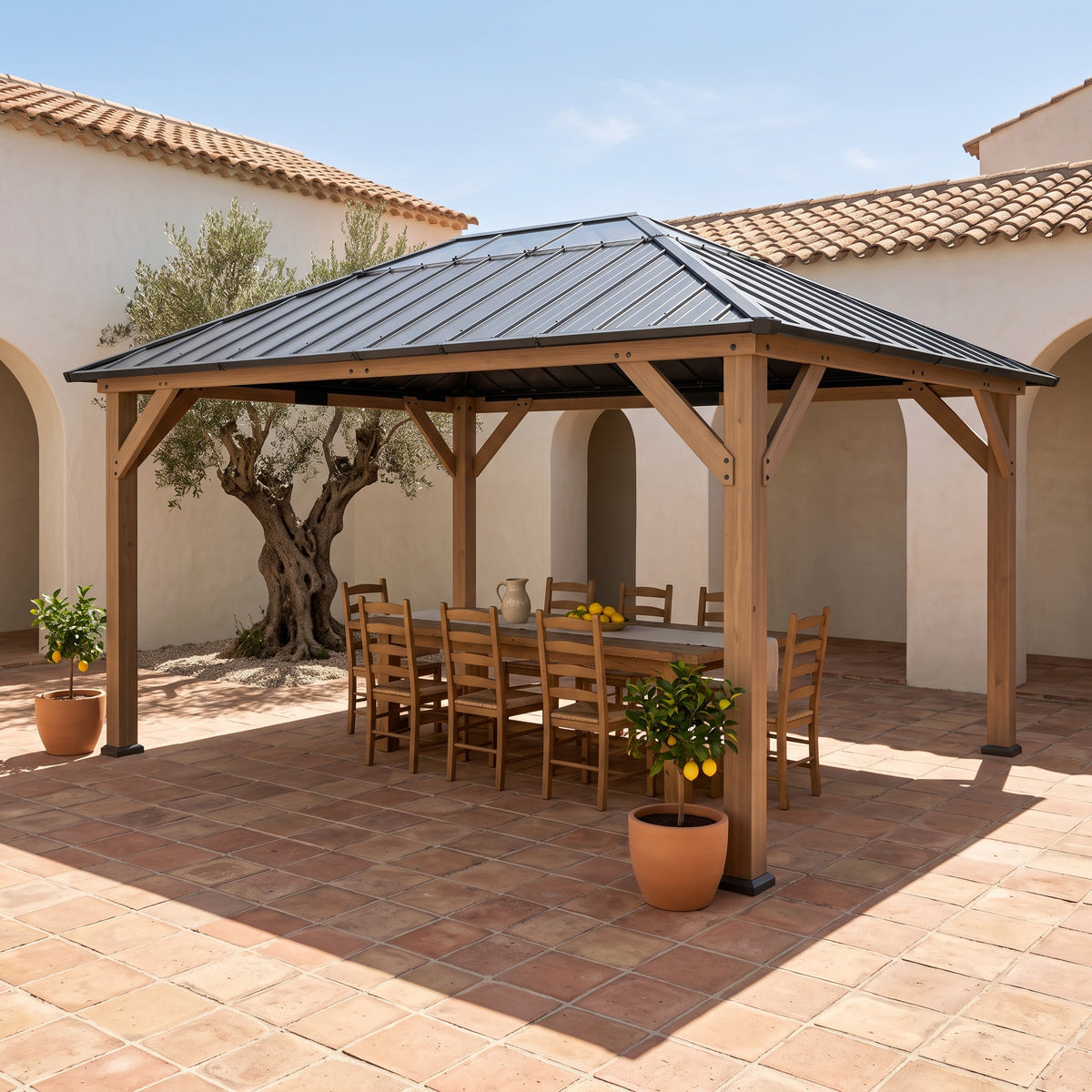 Gray steel hardtop gazebo with wood posts over a long dining table in a sunny terracotta courtyard