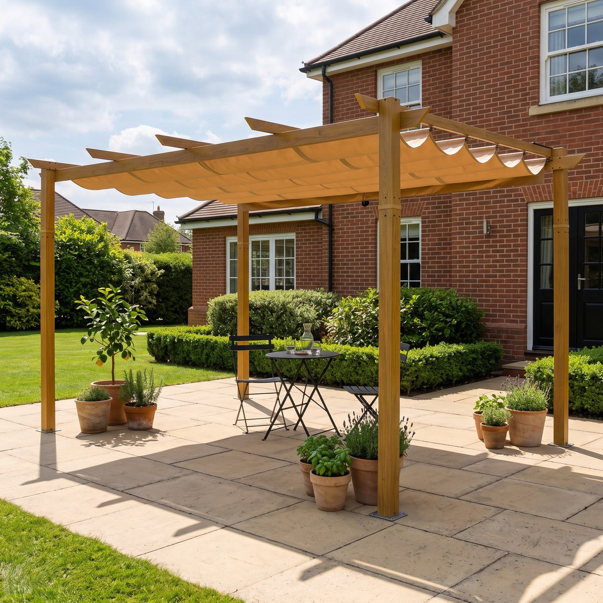 Yellow brown aluminum pergola with a beige retractable canopy over a bistro set on a stone patio by a brick house