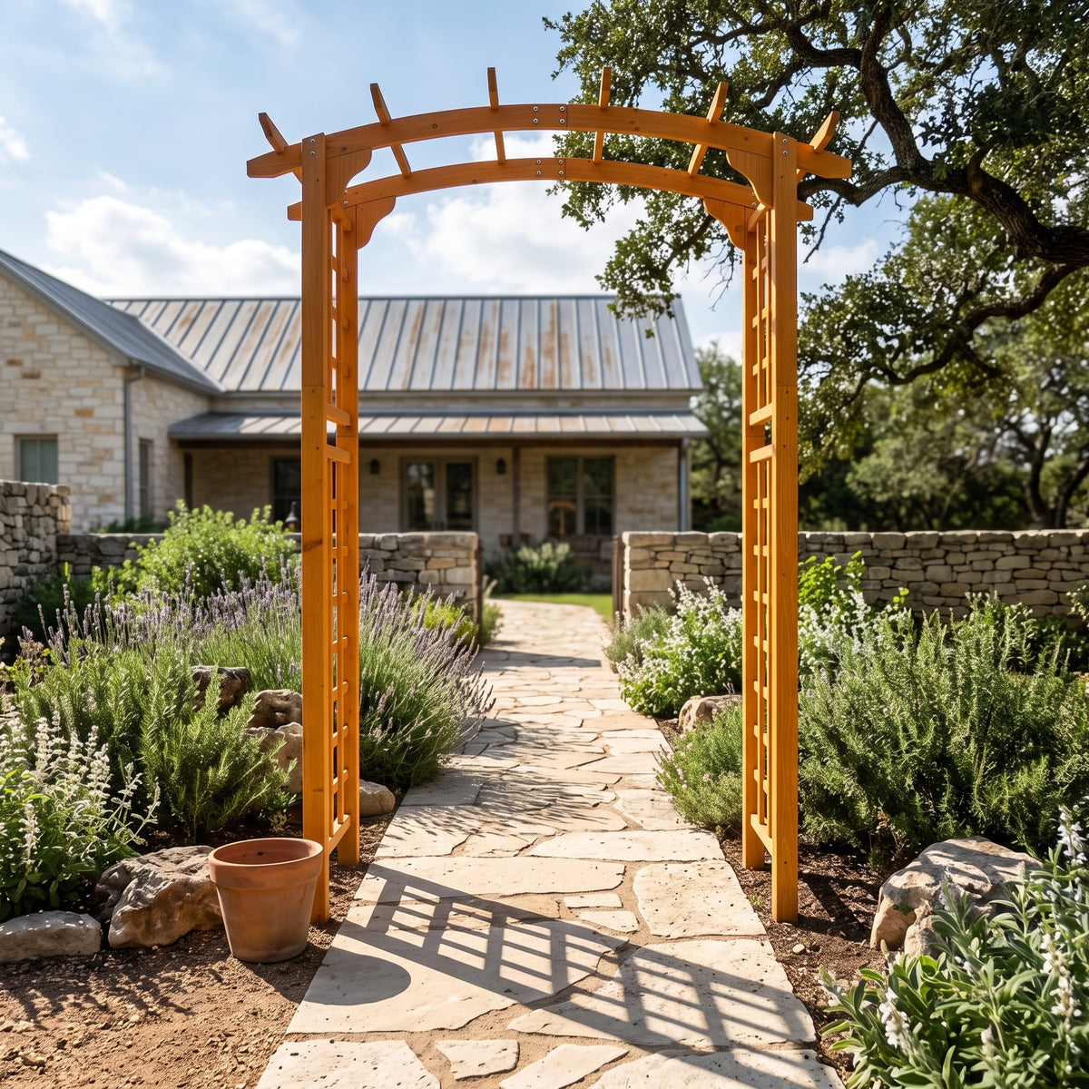 Yellow fir garden arbor arch over a flagstone path between lavender beds in front of a stone farmhouse