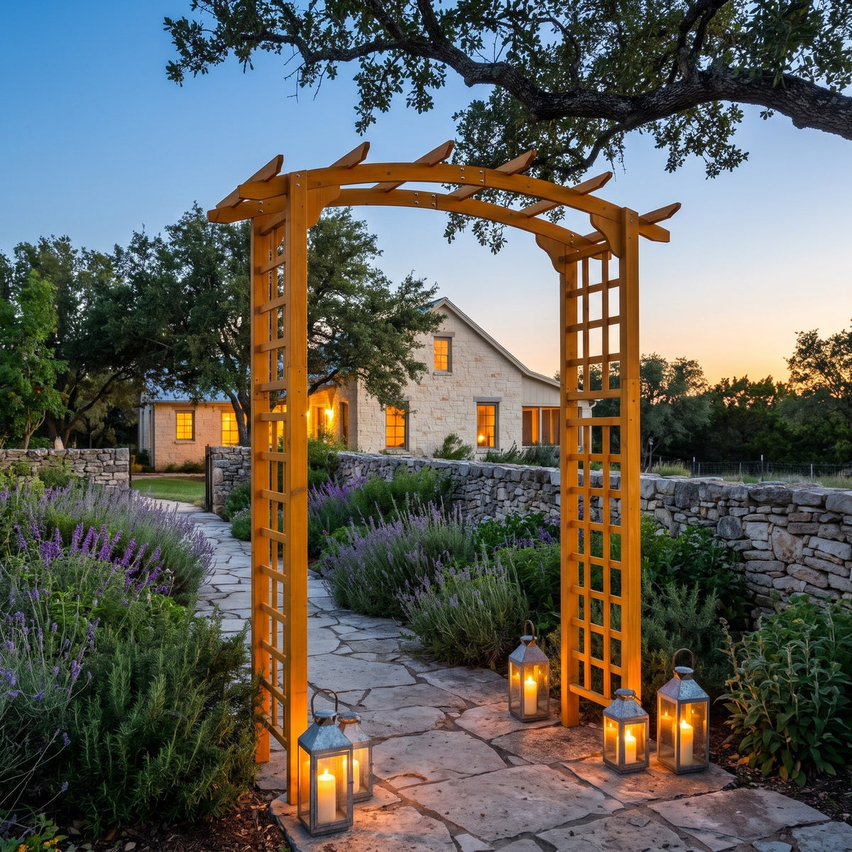 Yellow wood garden arbor arch over a flagstone path with lavender and candle lanterns at dusk