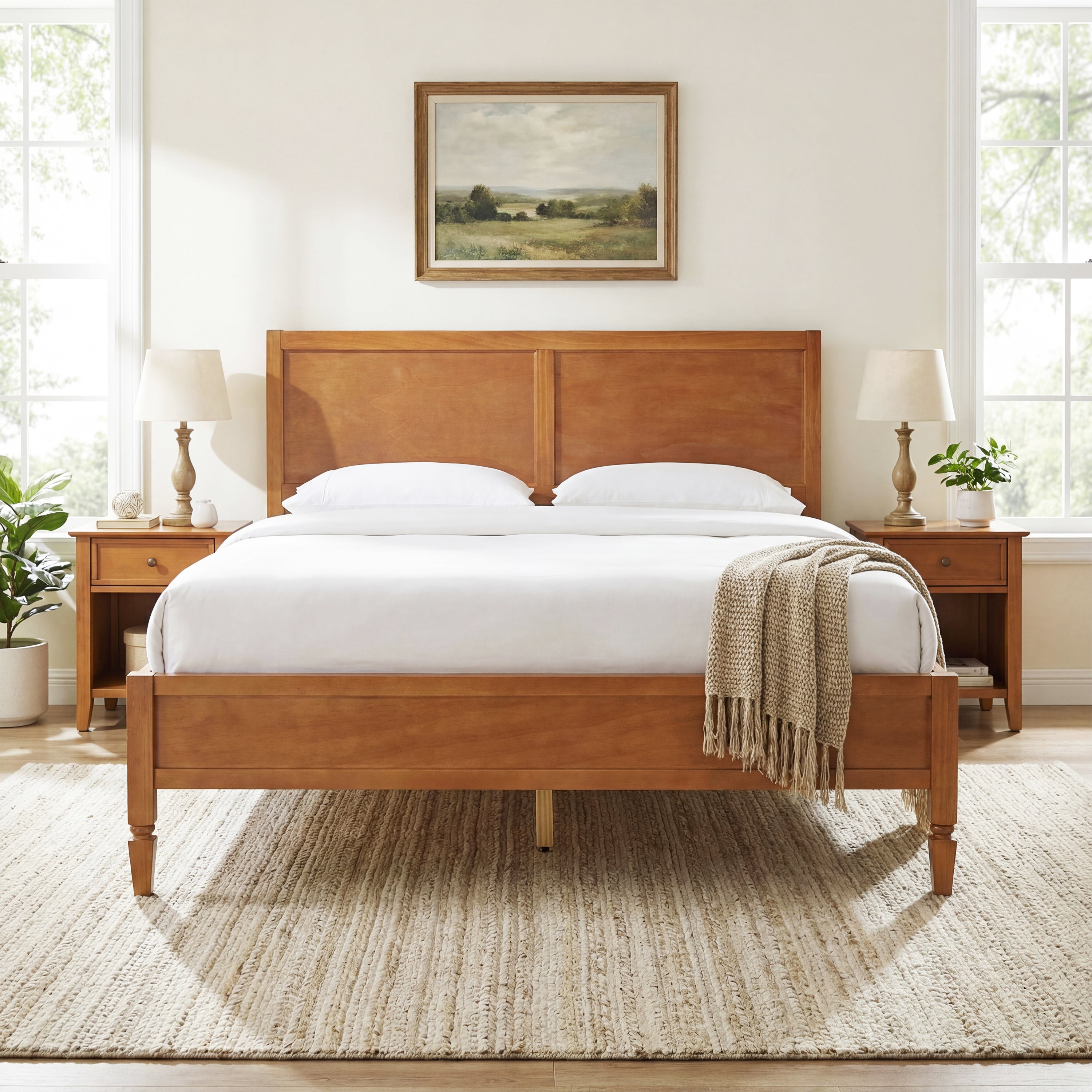 Brown wood platform bed styled with white bedding, panel headboard, matching nightstands, lamps and landscape art