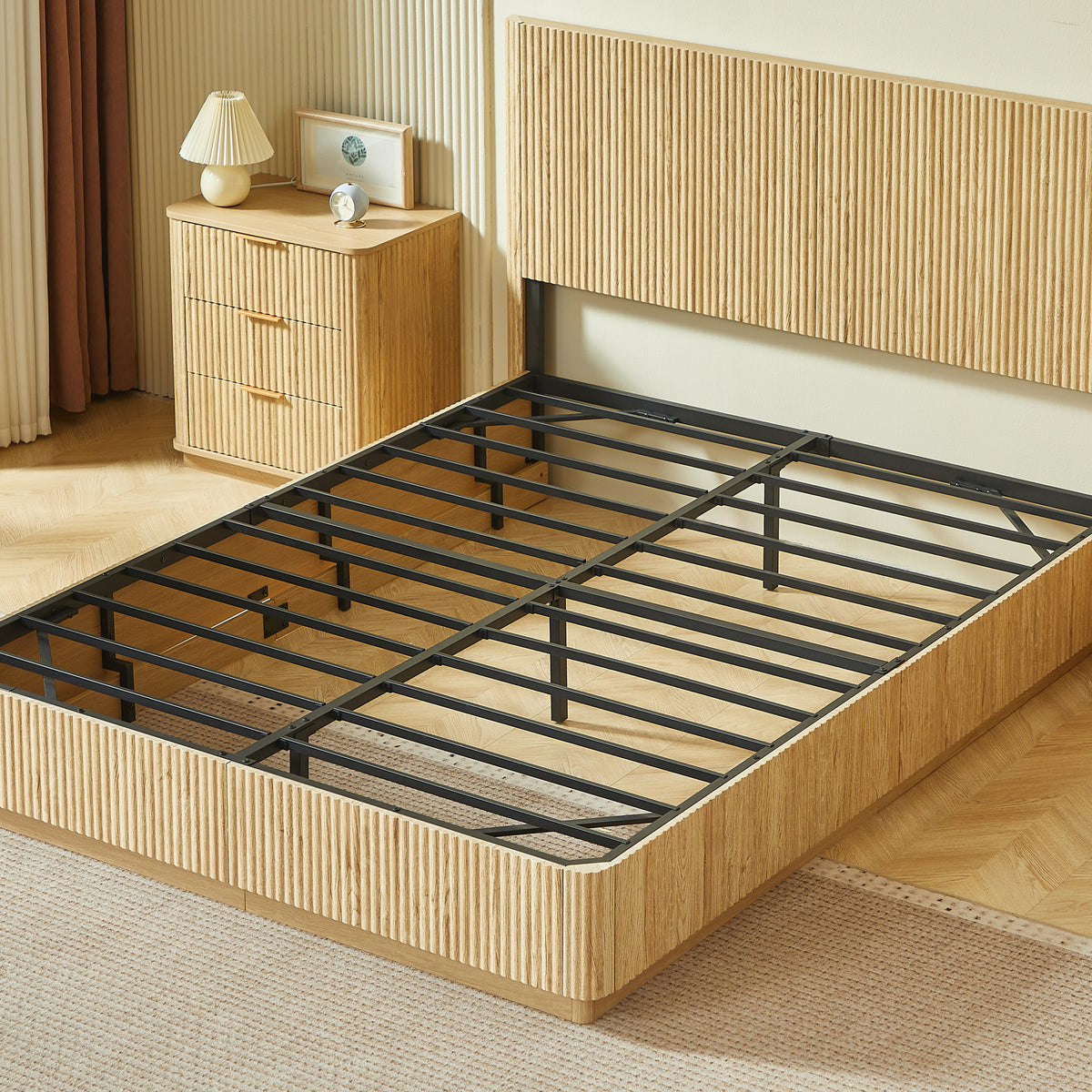 Angled view of light oak fluted queen bed frame with bare metal slats and a matching nightstand