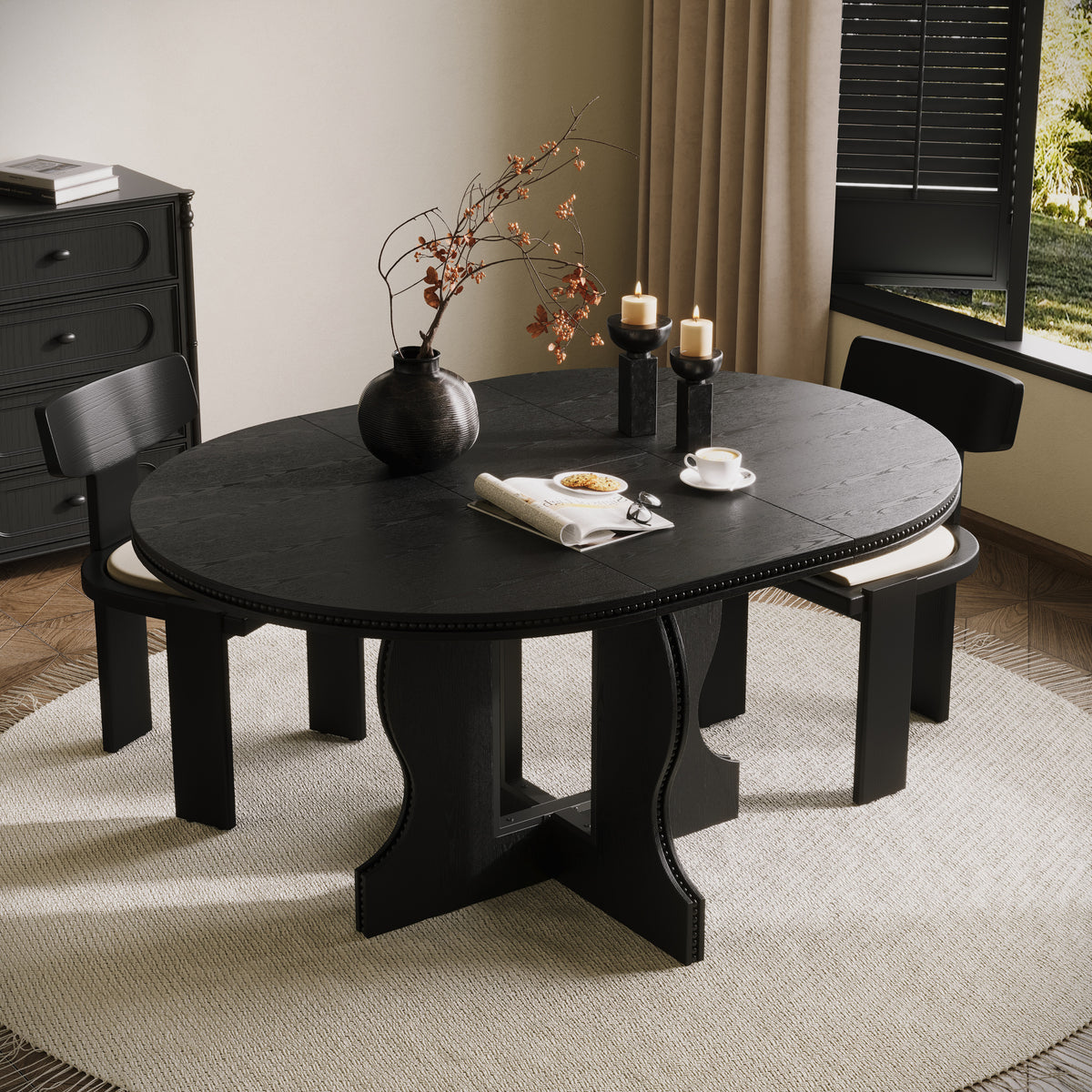 Black round pedestal dining table with two chairs, overhead angle in a styled dining room